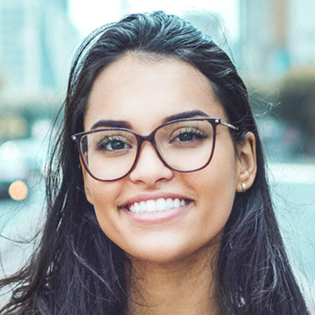 close up of beautiful young lady smiling and wearing glasses.