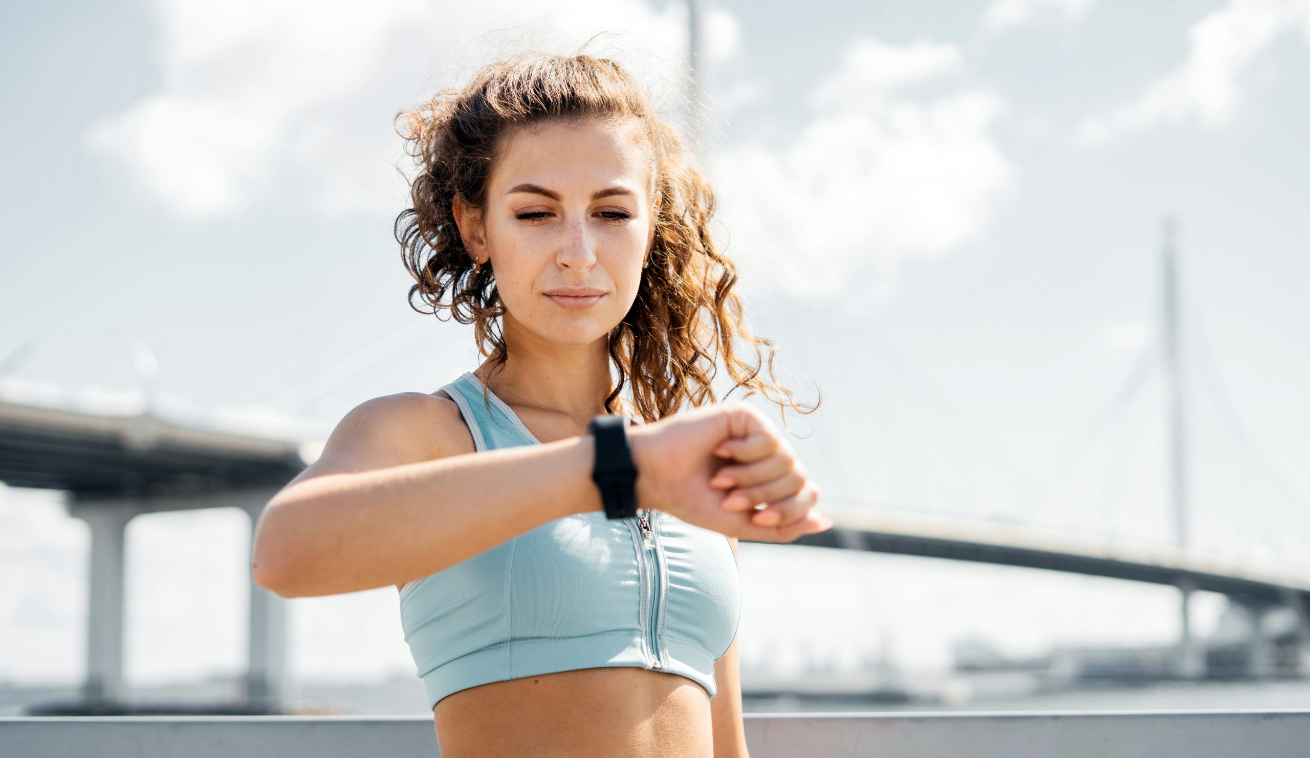 Beautiful woman in jogging attire checking her progress on a smartwatch.